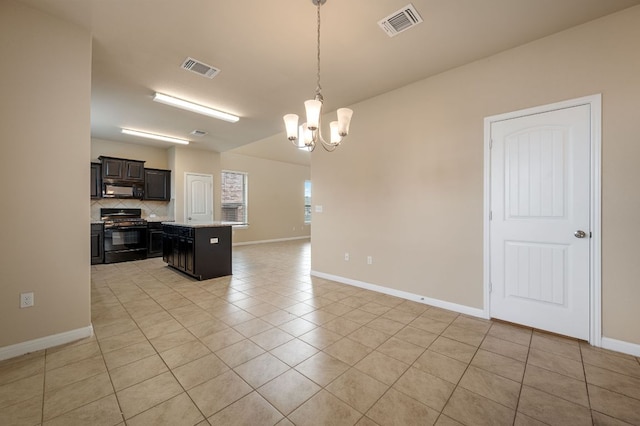 kitchen featuring an inviting chandelier, light tile patterned floors, black appliances, open floor plan, and baseboards