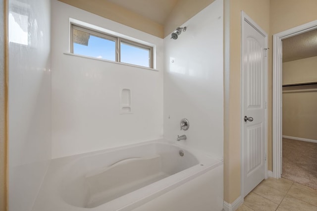 bathroom with a closet, tile patterned floors, baseboards, and washtub / shower combination