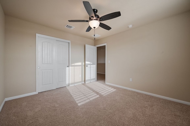 unfurnished bedroom featuring carpet floors, baseboards, a closet, and visible vents