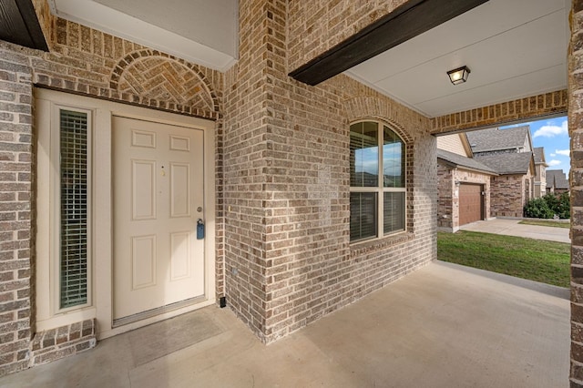 view of exterior entry featuring brick siding