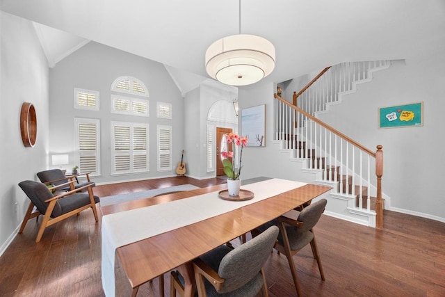 8909 Beatty Ct, Austin, TX 78749 - dining space featuring baseboards, wood finished floors, stairway, and high vaulted ceiling