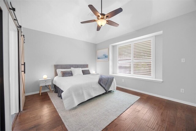 8909 Beatty Ct, Austin, TX 78749 - bedroom with a barn door, baseboards, and hardwood / wood-style flooring