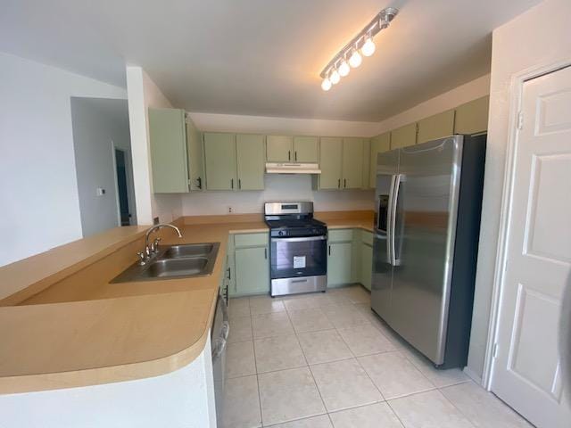 kitchen with appliances with stainless steel finishes, a sink, green cabinetry, and under cabinet range hood