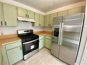12318 Marogot Run, Austin, TX 78758 - kitchen featuring stainless steel appliances, under cabinet range hood, green cabinetry, light countertops, and light tile patterned flooring