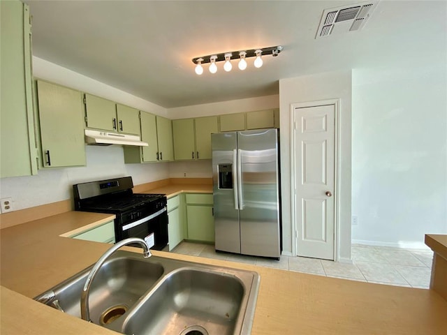 kitchen featuring stainless steel fridge with ice dispenser, gas stove, green cabinets, under cabinet range hood, and a sink