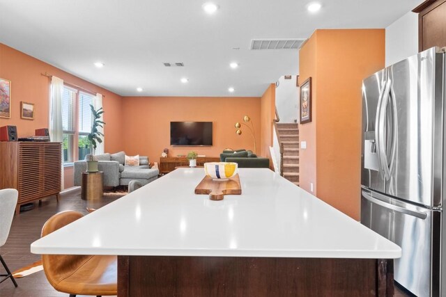 6809 Ellsworth Walk, Austin, TX 78724 - kitchen with stainless steel fridge with ice dispenser, dark wood-style floors, recessed lighting, a center island, and light countertops