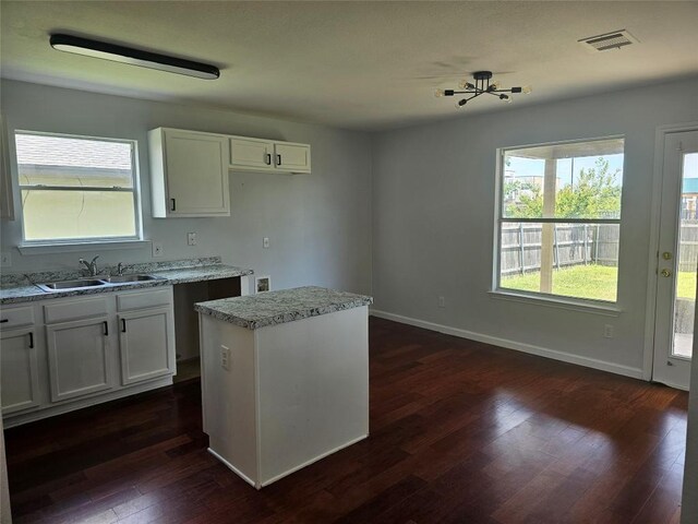 339 Liberty St, Hutto, TX 78634 - kitchen featuring dark wood finished floors, white cabinetry, a kitchen island, and light stone countertops