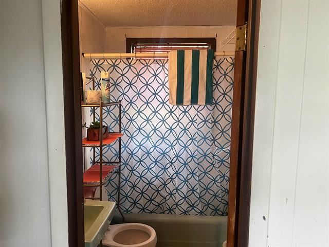 711 Council St, Burnet, TX 78611 - bathroom with a textured ceiling and toilet