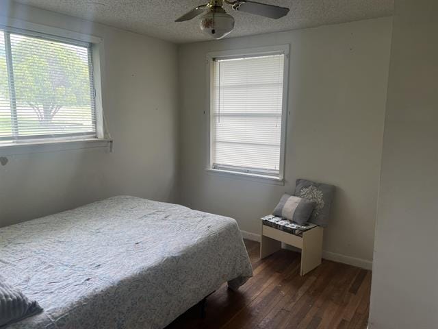 711 Council St, Burnet, TX 78611 - bedroom with a ceiling fan, baseboards, a textured ceiling, and dark wood-style flooring