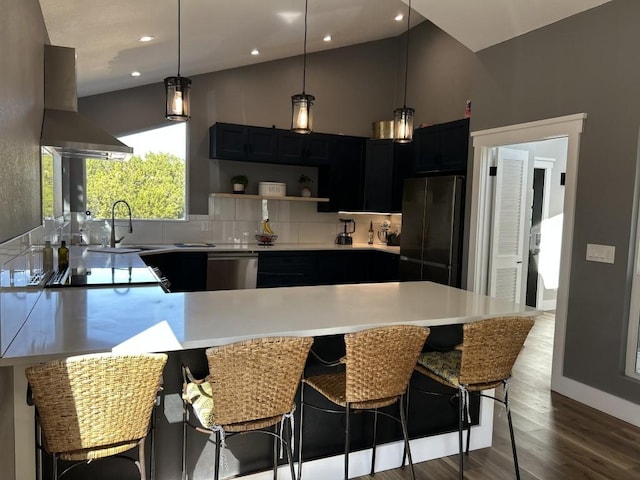 438 Eagle, Lakeway, TX 78734 - kitchen featuring a peninsula, light countertops, decorative backsplash, stainless steel appliances, and ventilation hood