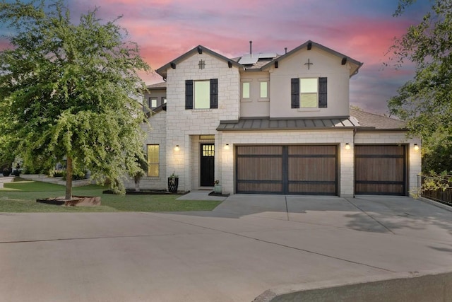 12705 Mitica Dr, Austin, TX 78739 - view of front of home featuring roof mounted solar panels, a standing seam roof, a lawn, metal roof, and concrete driveway