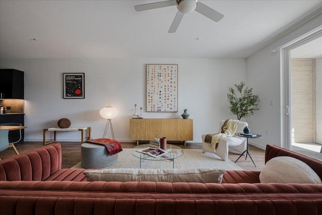 living room with baseboards, a ceiling fan, and wood finished floors