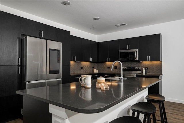 kitchen with dark countertops, dark cabinets, and stainless steel appliances