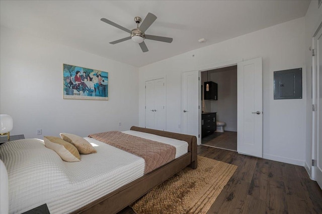 bedroom featuring ceiling fan, ensuite bath, electric panel, wood finished floors, and baseboards