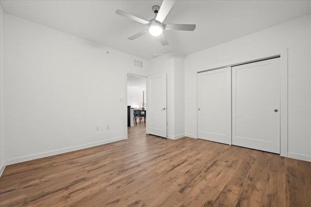 4801 Springdale Rd Unit 1107, Austin, TX 78723 - unfurnished bedroom featuring wood finished floors, baseboards, a closet, and ceiling fan