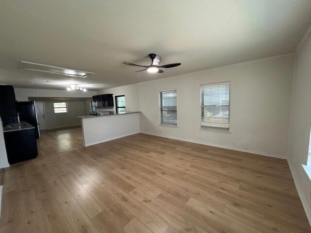 606 Springdale Rd, Austin, TX 78702 - unfurnished living room featuring attic access, ceiling fan, light wood-style floors, and baseboards
