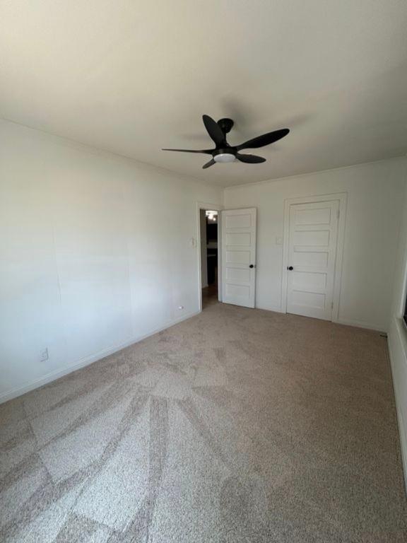 606 Springdale Rd, Austin, TX 78702 - unfurnished bedroom with light carpet, ceiling fan, and baseboards