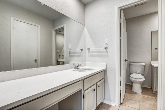 2109 Delvin Ln, Austin, TX 78728 - bathroom featuring tile patterned flooring, vanity, toilet, and a textured wall
