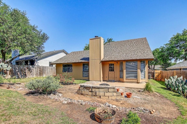 2109 Delvin Ln, Austin, TX 78728 - back of property featuring a chimney, a shingled roof, and an outdoor fire pit