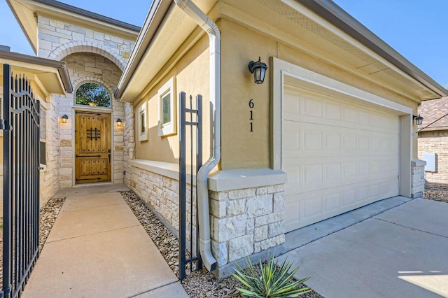611 Algerita Dr, Georgetown, TX 78628 - property entrance featuring stone siding, a garage, and stucco siding