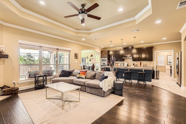 611 Algerita Dr, Georgetown, TX 78628 - living area with a tray ceiling, a ceiling fan, arched walkways, recessed lighting, and hardwood / wood-style floors