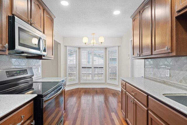 3504 Valley Pike Rd, Cedar Park, TX 78613 - kitchen with appliances with stainless steel finishes, dark wood-style flooring, baseboards, a chandelier, and decorative backsplash