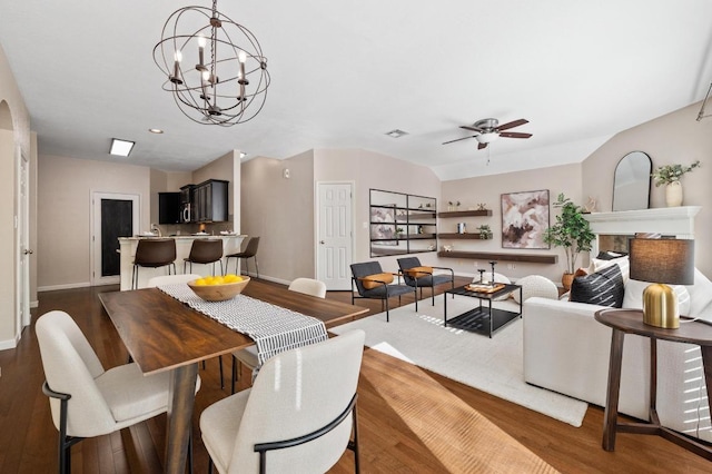 dining space with ceiling fan with notable chandelier, arched walkways, visible vents, baseboards, and dark wood-style floors