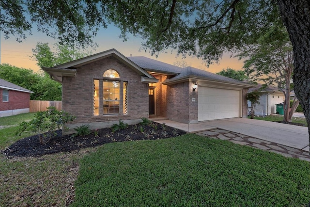 single story home with brick siding, an attached garage, driveway, and a front lawn