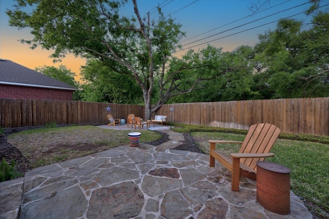 patio terrace at dusk with a fenced backyard