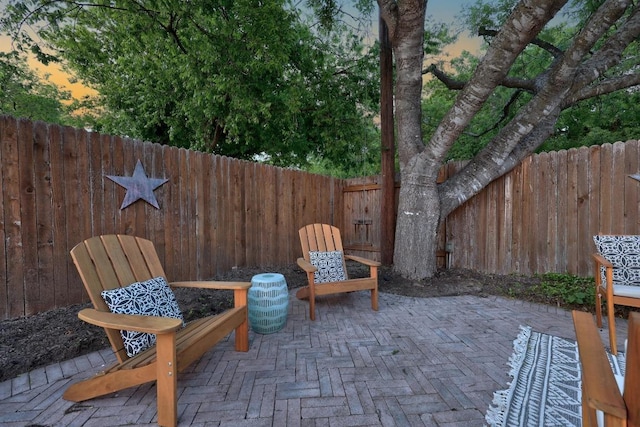 patio terrace at dusk with a fenced backyard