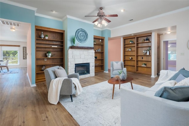 11134 Bonham Ranch Rd, Dripping Springs, TX 78620 - living area featuring wood finished floors, a fireplace, a ceiling fan, baseboards, and crown molding