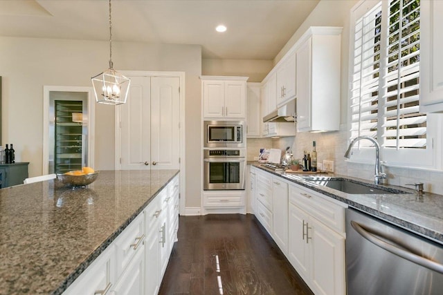 101 Amiata Ave Unit 104, Austin, TX 78734 - kitchen featuring appliances with stainless steel finishes, white cabinets, dark stone countertops, a chandelier, and recessed lighting