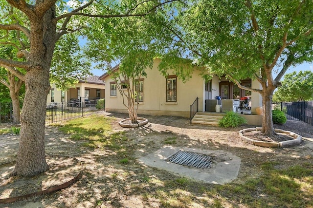 back of property with fence, stucco siding, and a porch