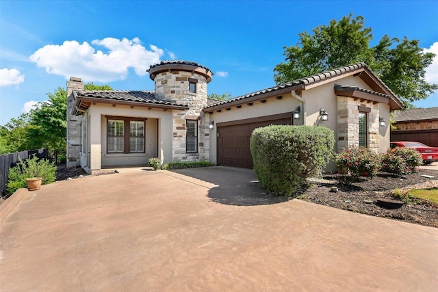 mediterranean / spanish home featuring stucco siding, a garage, a tile roof, driveway, and stone siding