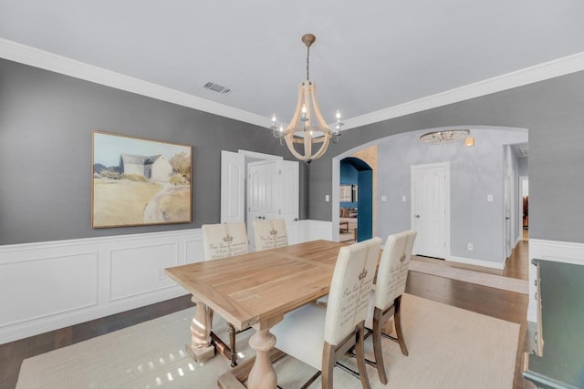 1505 Lake Forest Cv, Round Rock, TX 78665 - dining room with arched walkways, a chandelier, ornamental molding, and wood finished floors