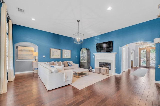 1505 Lake Forest Cv, Round Rock, TX 78665 - living room with arched walkways, french doors, wood finished floors, baseboards, and a glass covered fireplace