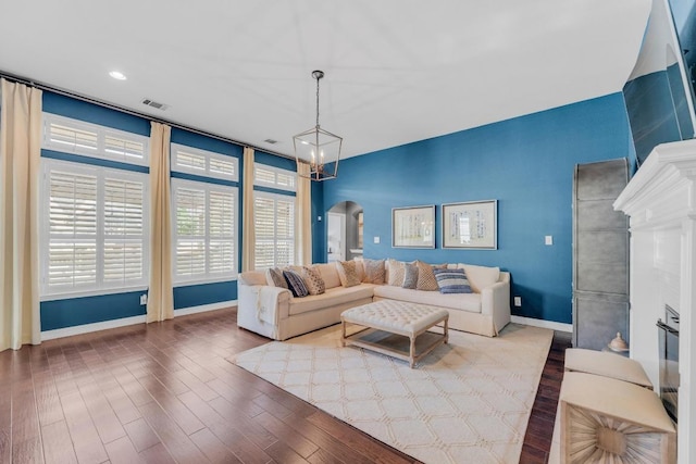 1505 Lake Forest Cv, Round Rock, TX 78665 - living area featuring arched walkways, baseboards, wood finished floors, and a fireplace