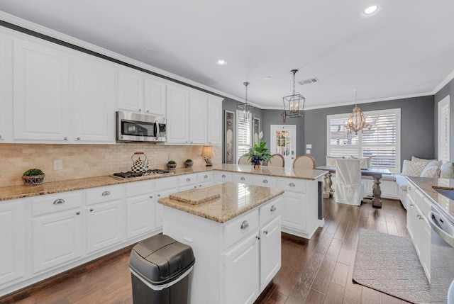 1505 Lake Forest Cv, Round Rock, TX 78665 - kitchen with stainless steel appliances, ornamental molding, a peninsula, dark wood finished floors, and a chandelier