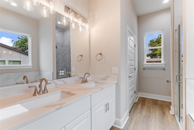 650 Aspen Ln, Cottonwood Shores, TX 78657 - full bathroom with plenty of natural light, double vanity, wood finished floors, and a shower with shower door