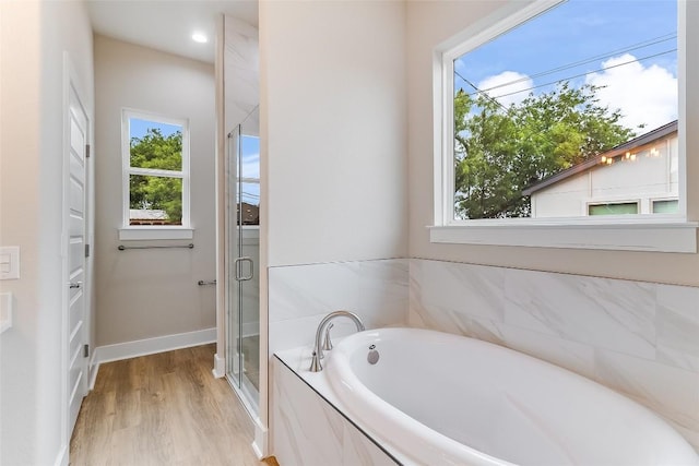 650 Aspen Ln, Cottonwood Shores, TX 78657 - full bathroom with plenty of natural light, a shower stall, a bath, and wood finished floors