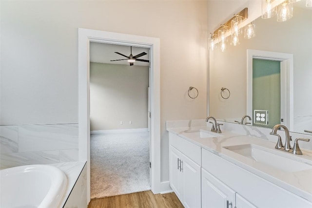 650 Aspen Ln, Cottonwood Shores, TX 78657 - full bathroom featuring double vanity, wood finished floors, a tub, and a ceiling fan