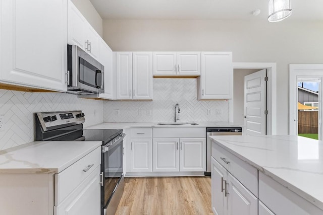 650 Aspen Ln, Cottonwood Shores, TX 78657 - kitchen with appliances with stainless steel finishes, white cabinetry, and light wood-style flooring