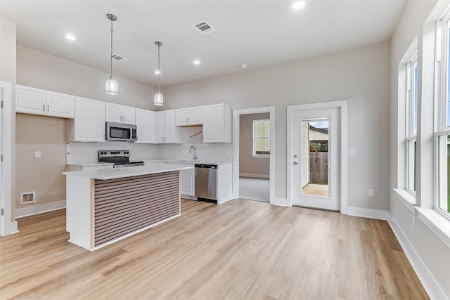 650 Aspen Ln, Cottonwood Shores, TX 78657 - kitchen with stainless steel appliances, light countertops, tasteful backsplash, white cabinetry, and light wood finished floors