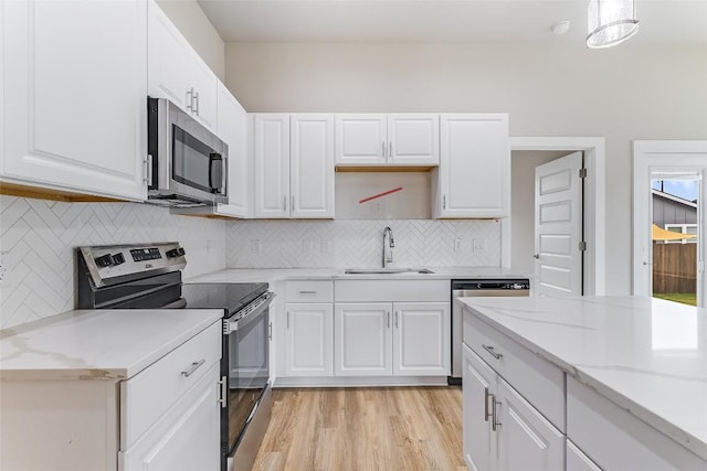 650 Aspen Ln, Cottonwood Shores, TX 78657 - kitchen with stainless steel appliances, light wood finished floors, and white cabinetry