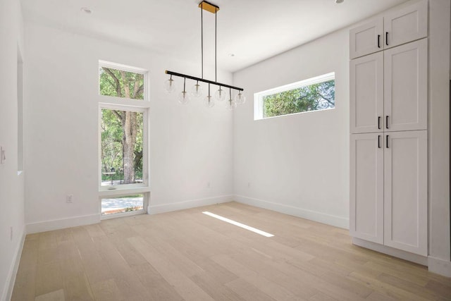 unfurnished room with light wood finished floors and baseboards