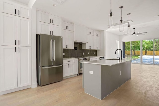 kitchen featuring tasteful backsplash, a ceiling fan, white cabinets, appliances with stainless steel finishes, and a sink