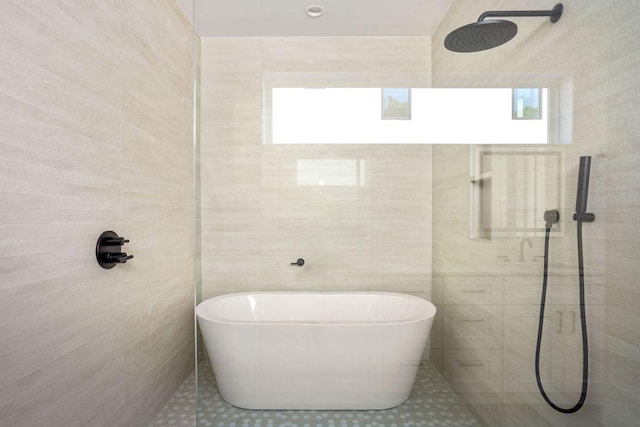 full bath with tiled shower, tile walls, tile patterned flooring, and a soaking tub