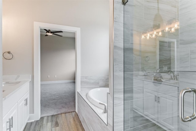 652 Aspen Ln, Cottonwood Shores, TX 78657 - full bath featuring ceiling fan, vanity, a shower stall, a garden tub, and wood finished floors