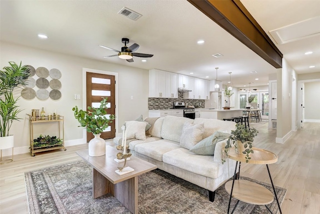 6007 Belfast Dr, Austin, TX 78723 - living room with light wood finished floors, a ceiling fan, and recessed lighting