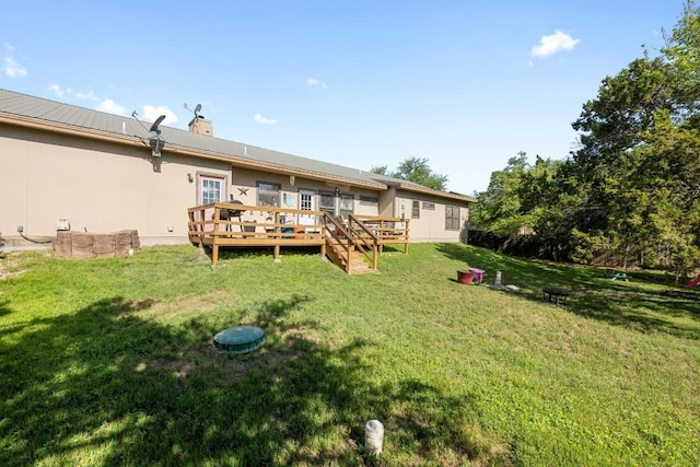 201 Loving Trl, Dripping Springs, TX 78620 - back of property with a wooden deck, a lawn, a chimney, metal roof, and stucco siding